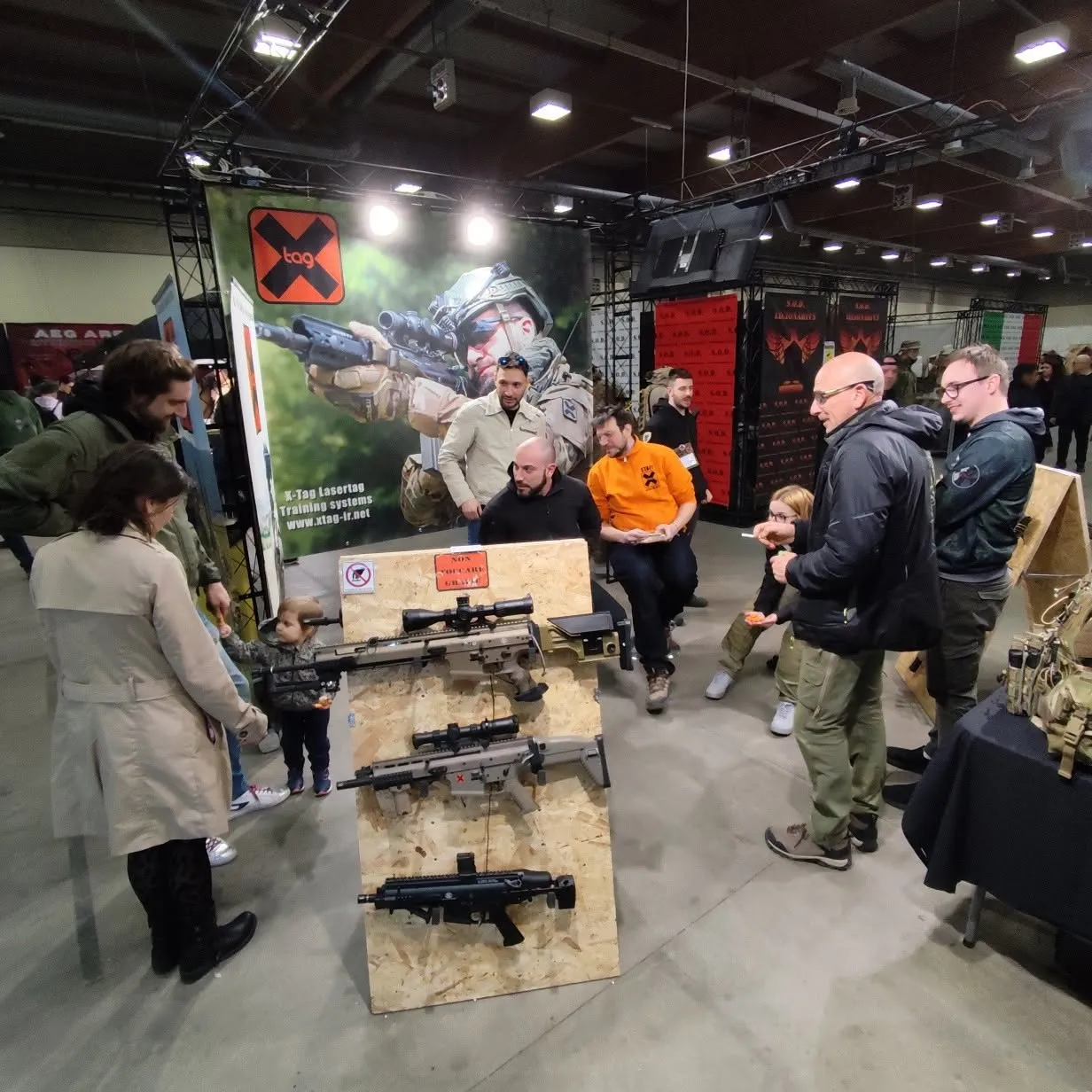 X-Tag booth at an industry trade fair, with replicas on display and visitors
