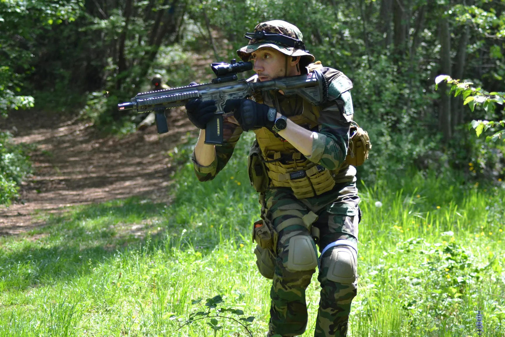Giocatore X-Tag con kit completo (headset e arma) in azione nel bosco