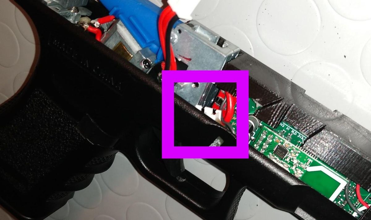 Il connettore della batteria incollato sul fianco destro, nel riquadro viola
